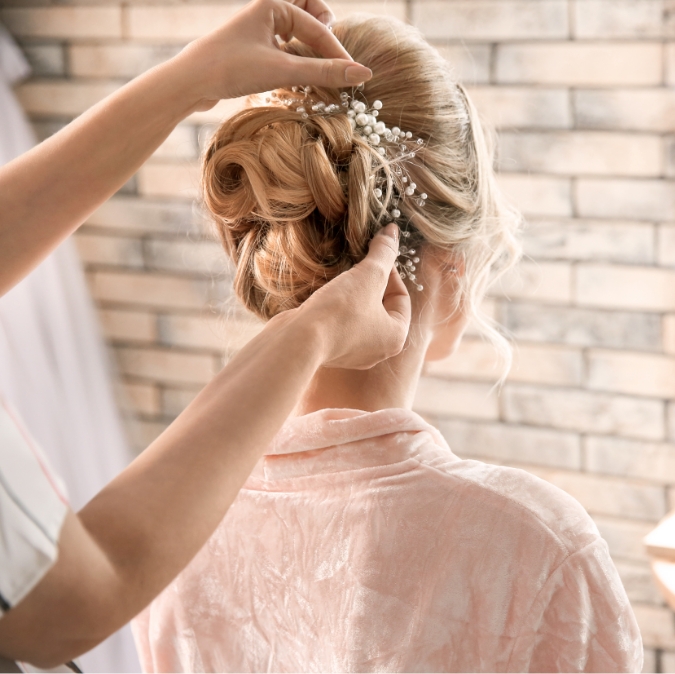 Bride getting hair pinned with pearls